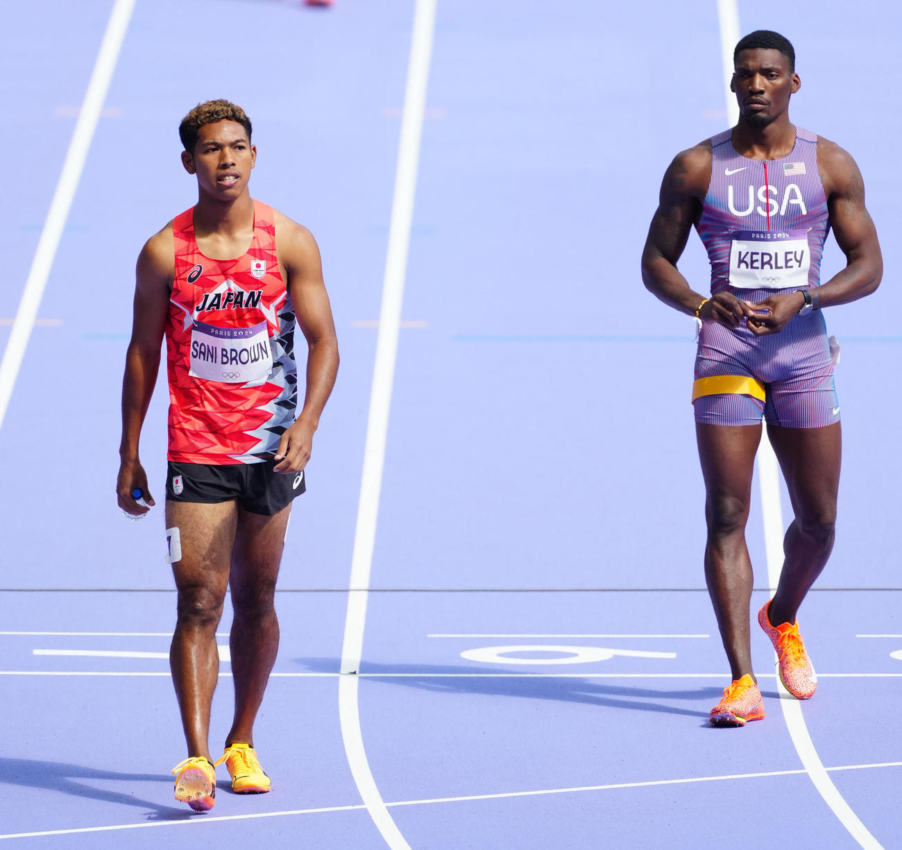 男子400メートルリレー予選のスタート位置に向かう1走のサニブラウン（左）。右は米国のカーリー（撮影・江口和貴）