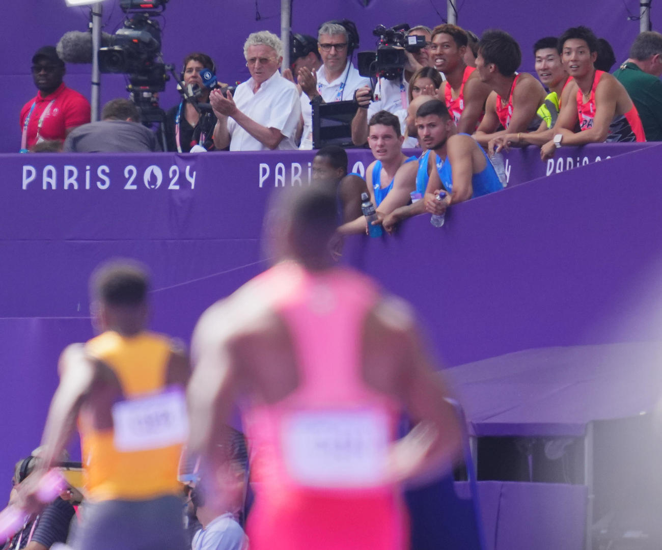 陸上男子400メートルリレー予選、ミックスゾーンから心配そうに予選2組目のレースを見つめる日本の選手たち（右上）（撮影・垰建太）