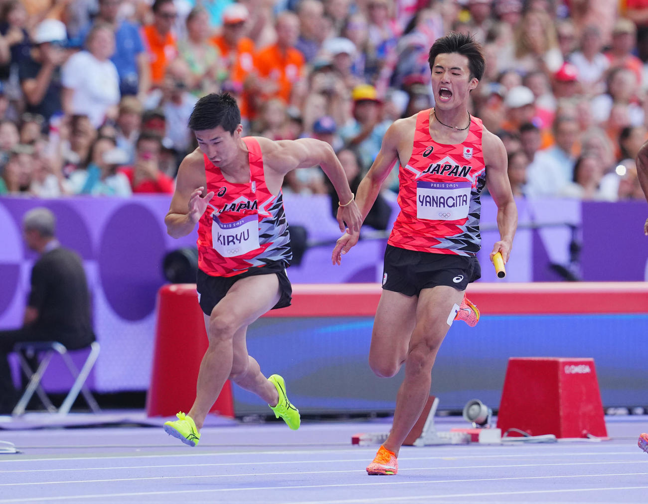 陸上男子400メートルリレー予選、2走柳田（右）は3走桐生にバトンを渡す（撮影・垰建太）
