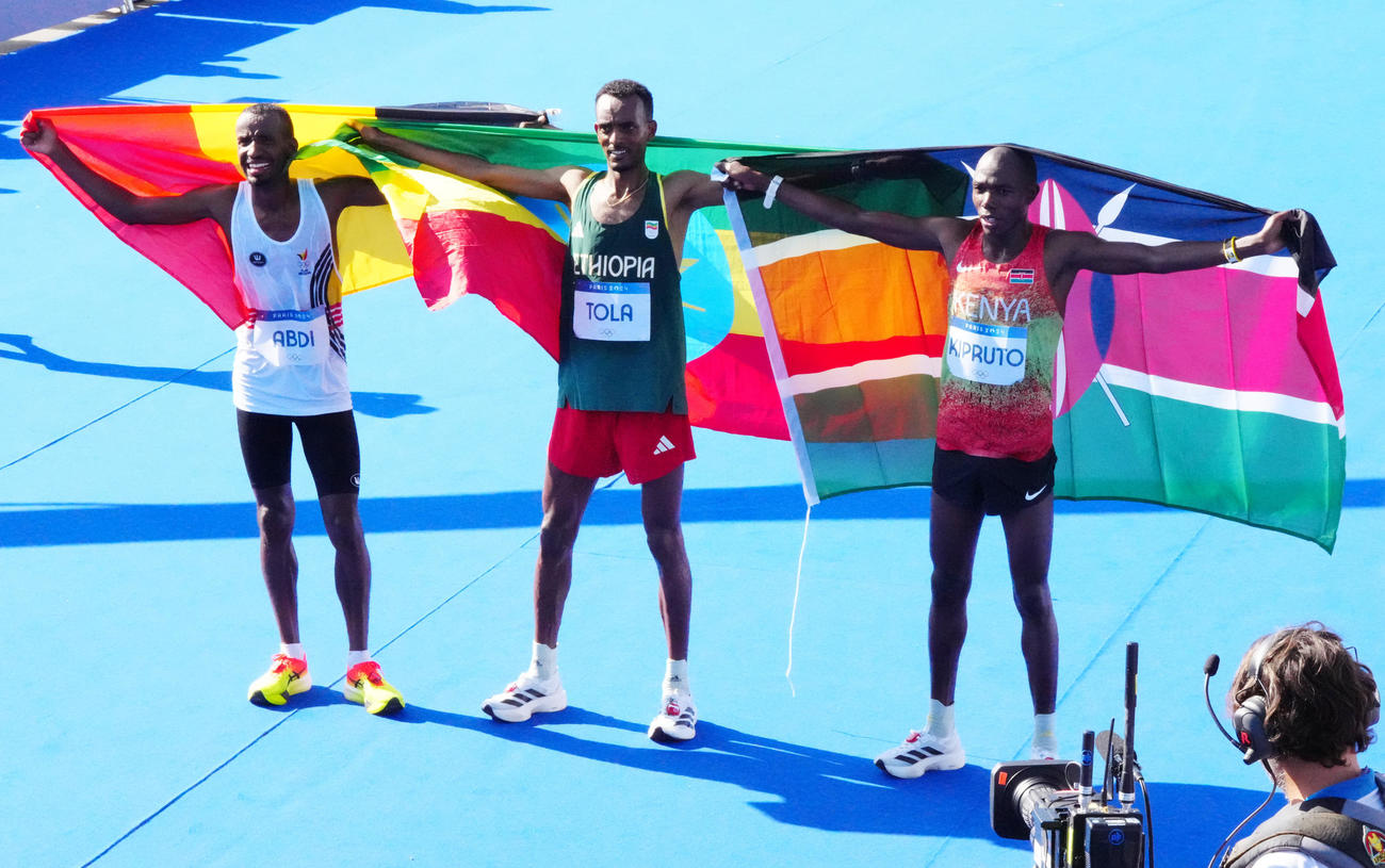 男子マラソンで優勝したエチオピアのタミラト・トラ（中央）。左は2位のベルギー・アブディ、右は3位のケニア・キプルト（撮影・江口和貴）