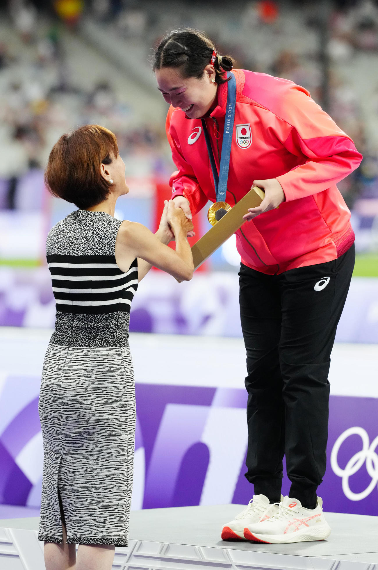 女子やり投げの表彰式でプレゼンターの有森さん（左）と握手を交わす金メダルの北口（2024年8月10日撮影）