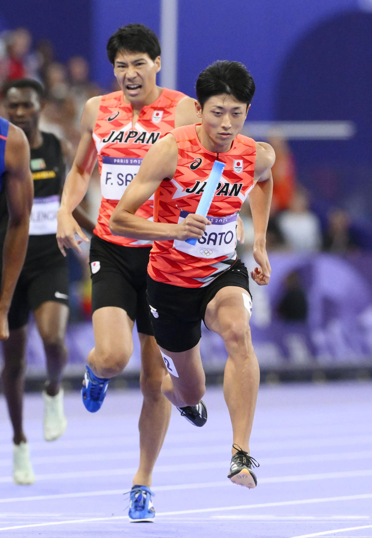 男子1600メートルリレー決勝　第3走者の佐藤風雅（奥）からバトンを受け、駆け出すアンカーの佐藤拳太郎（共同）