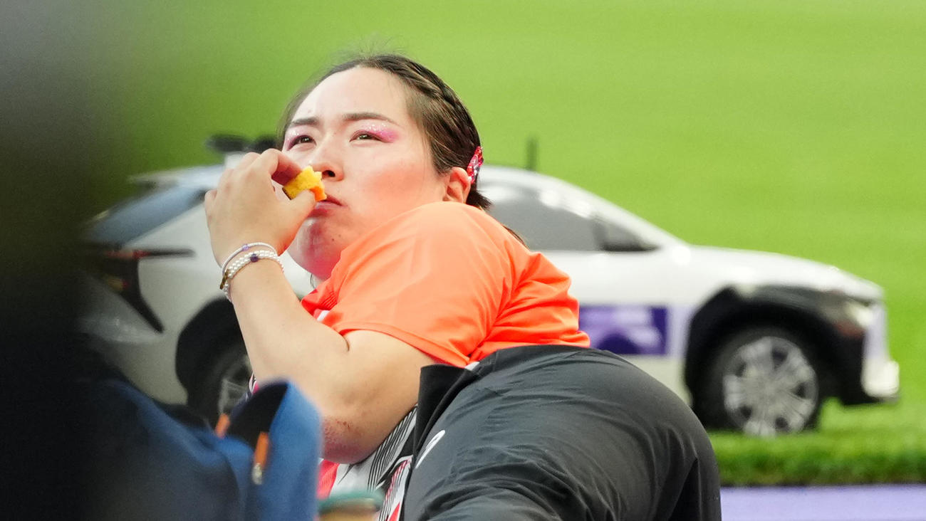 女子やり投げ決勝で3投目を終え、カステラを食べる北口（撮影・江口和貴）