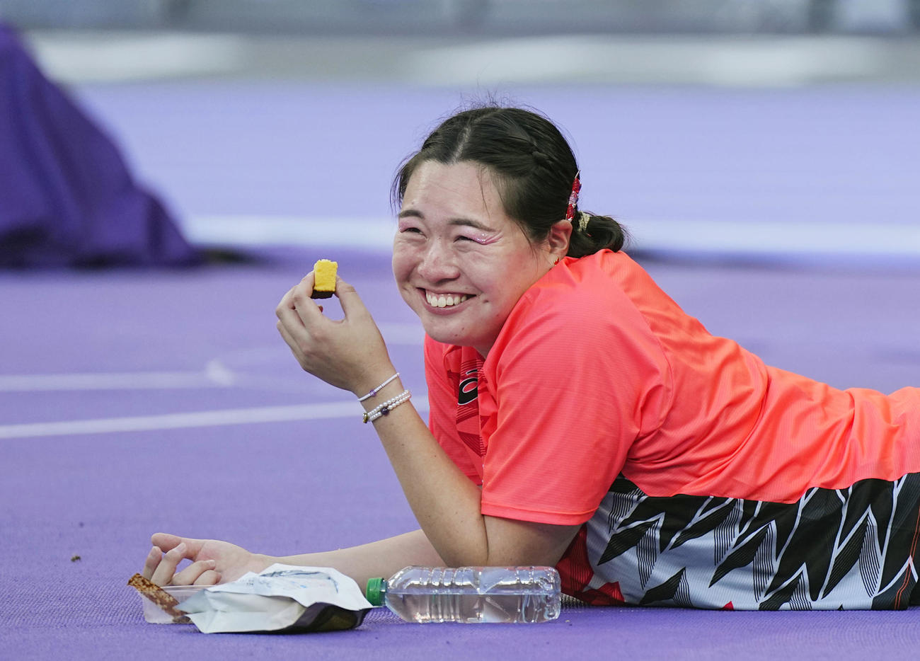 女子やり投げ決勝　投てきの合間にカステラをほおばる北口（代表撮影）