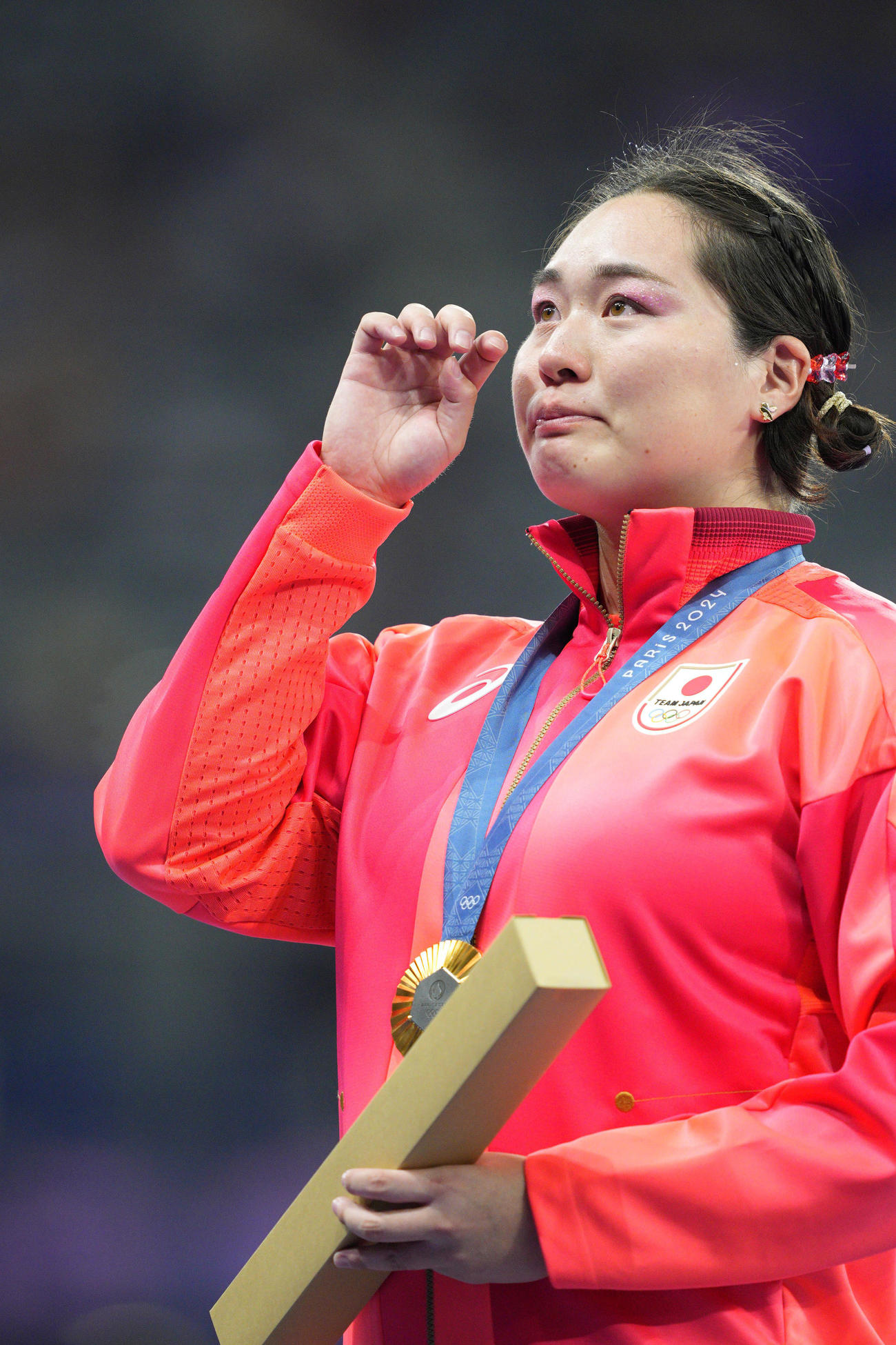 女子やり投げで金メダルを獲得し、表彰式で涙を拭う北口榛花（共同）