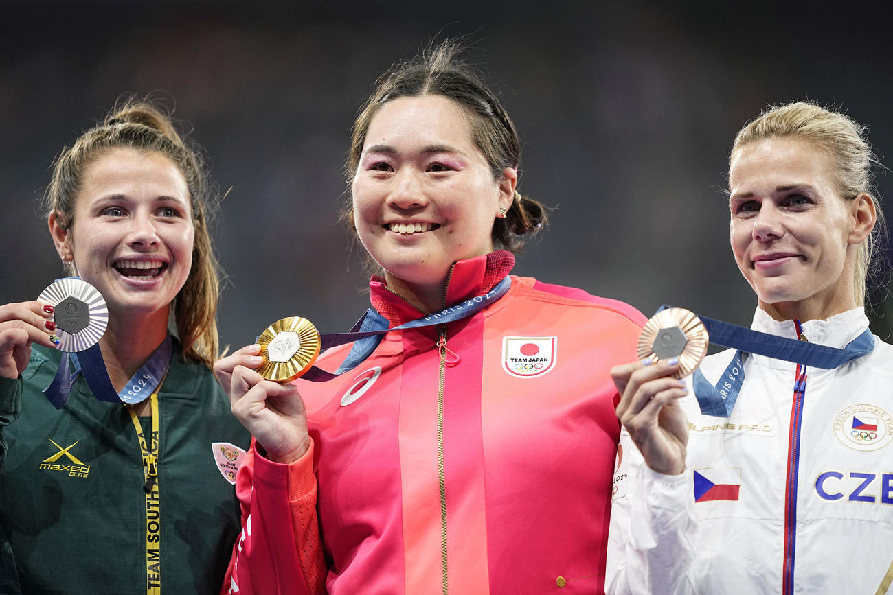 女子やり投げで金メダルを獲得し、表彰式で笑顔の北口榛花（中央）共同）