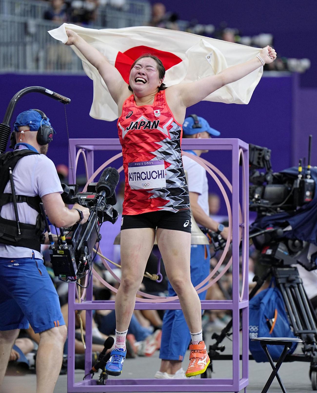 女子やり投げで金メダルを獲得し、日の丸を掲げる北口榛花（共同）