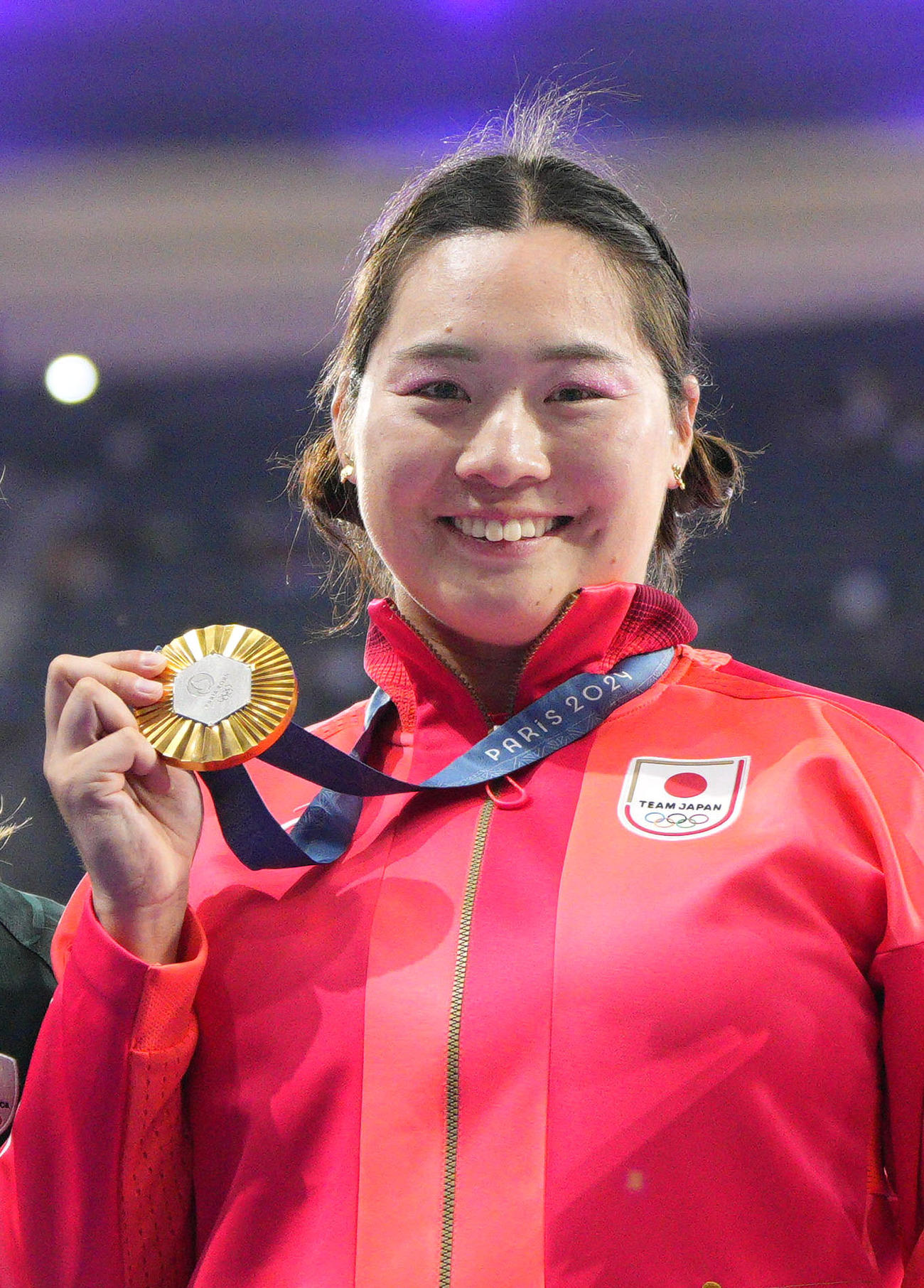 女子やり投げで優勝し、表彰式で金メダルを手に笑顔の北口榛花（共同）