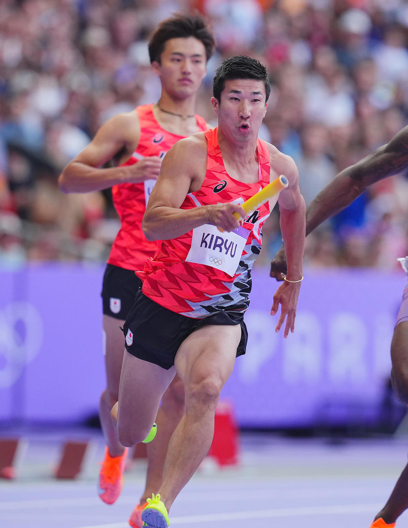 陸上男子400メートルリレー予選、2走柳田（奥）からバトンを受け取り走り出す3走桐生（撮影・垰建太）