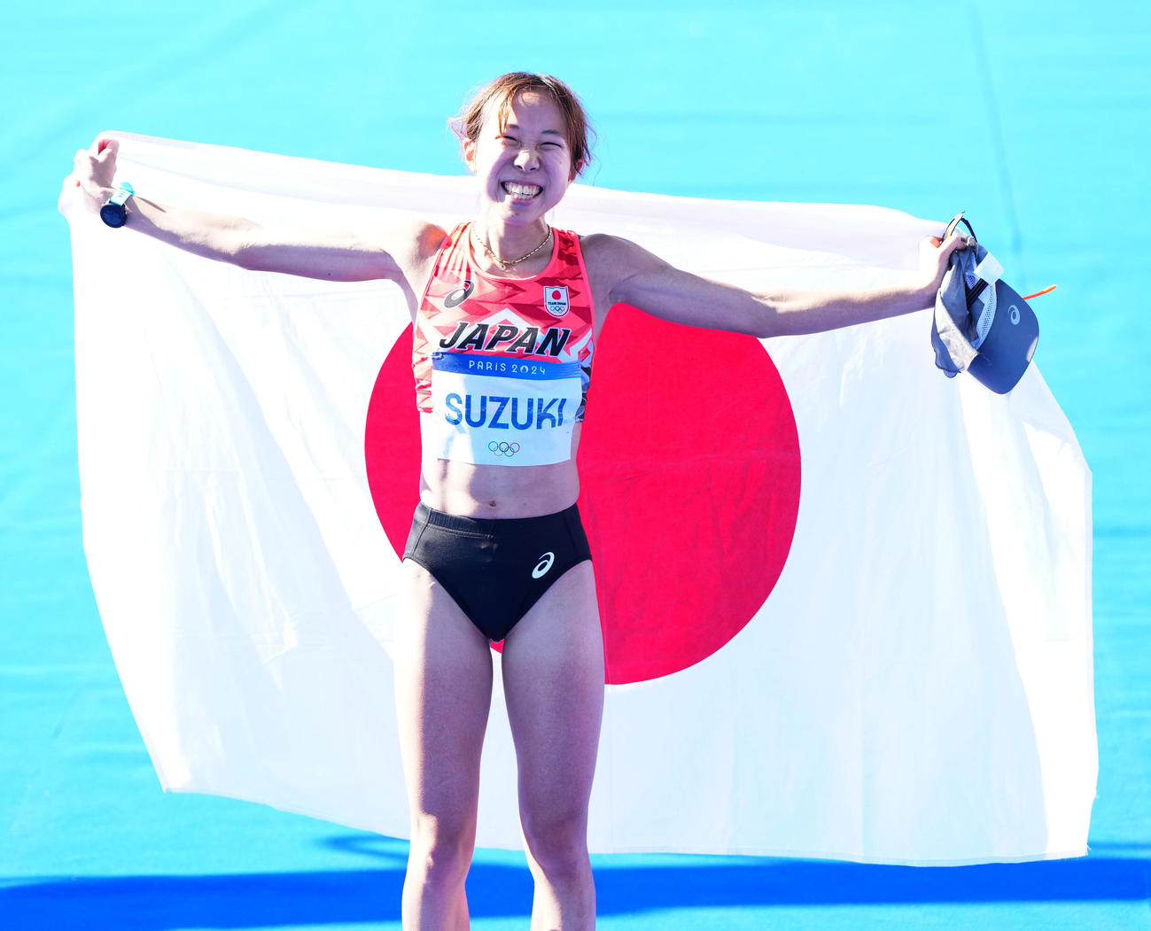 女子マラソンで6位入賞し日の丸を掲げる鈴木（撮影・江口和貴）