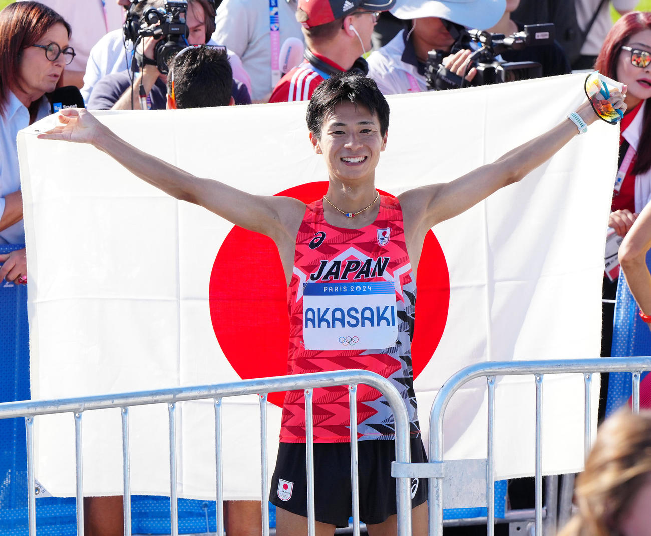男子マラソンで6位入賞し日の丸を掲げる赤崎（2024年8月10日撮影）