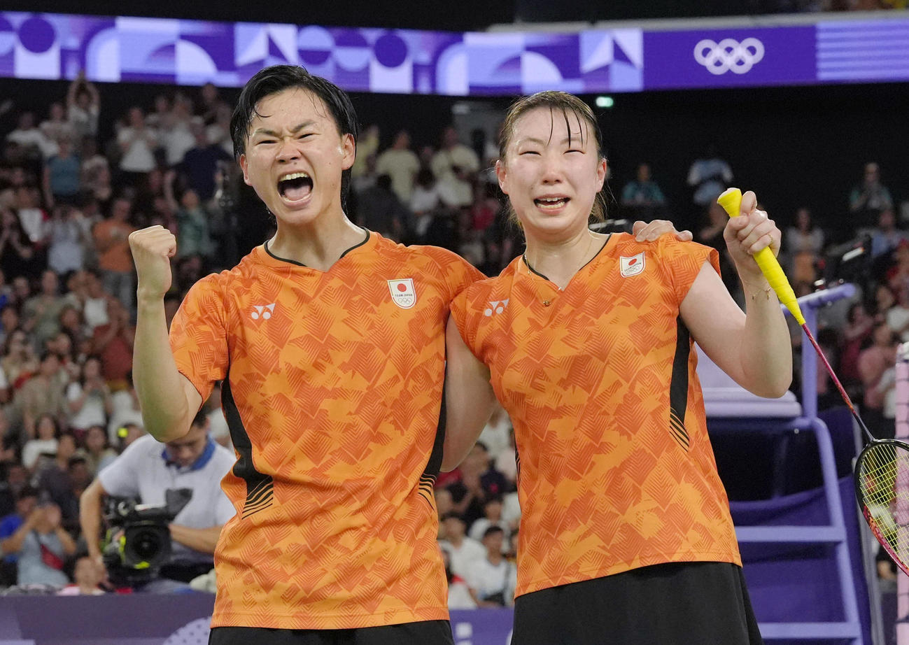 パリ五輪のバドミントン混合ダブルスで銅メダルを獲得し、ガッツポーズする渡辺勇大（左）と東野有紗＝2日、パリ（共同）