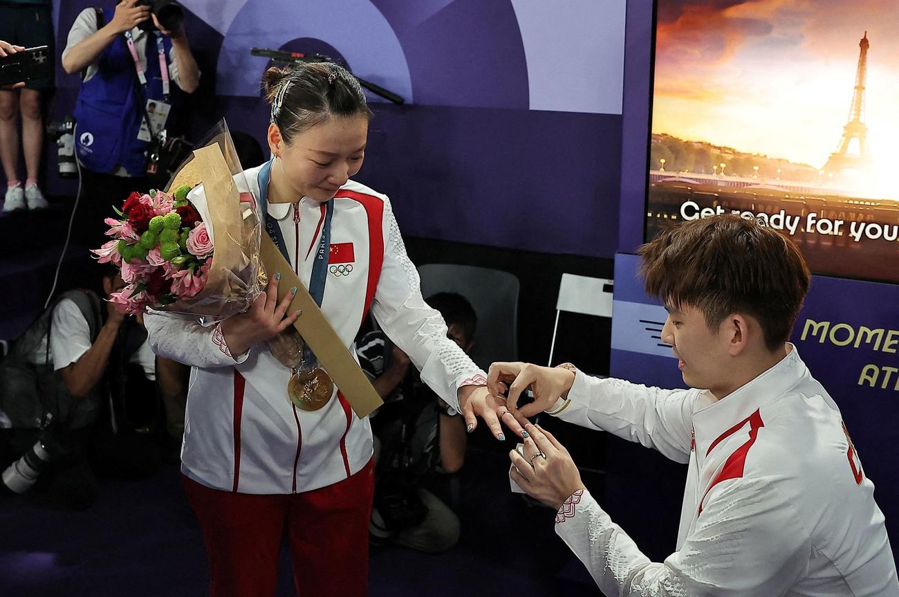 バドミントン混合ダブルスの表彰式後に優勝した中国の黄雅瓊（左）はペアを組む劉雨辰から公開プロポーズを受けた（ロイター）