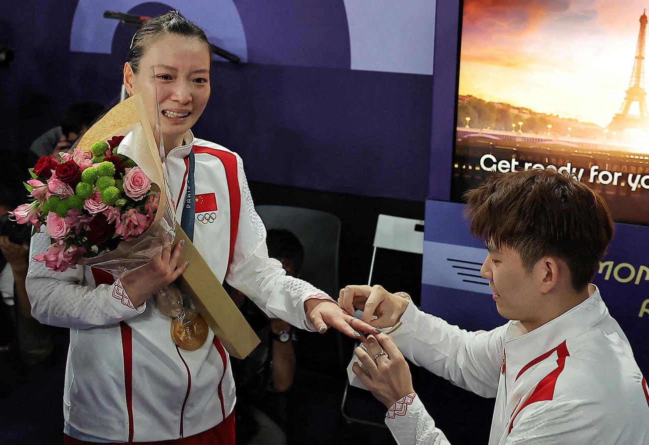 バドミントン混合ダブルスの表彰式後に優勝した中国の黄雅瓊（左）はペアを組む劉雨辰から公開プロポーズを受けた（ロイター）