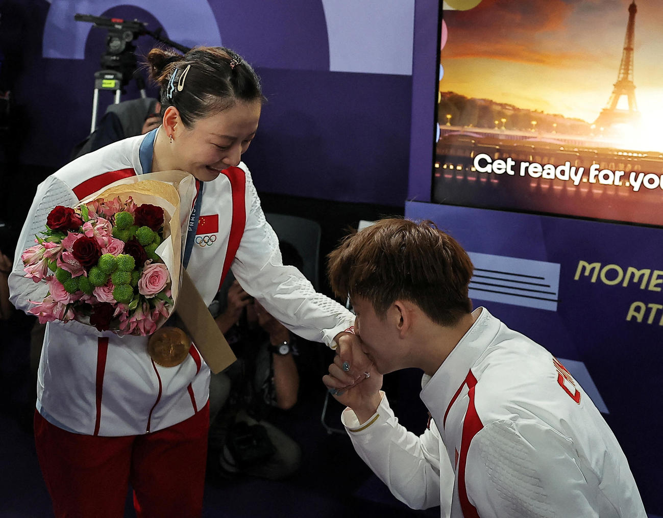 バドミントン混合ダブルスの表彰式後に優勝した中国の黄雅瓊（左）はペアを組む劉雨辰から公開プロポーズを受けた（ロイター）