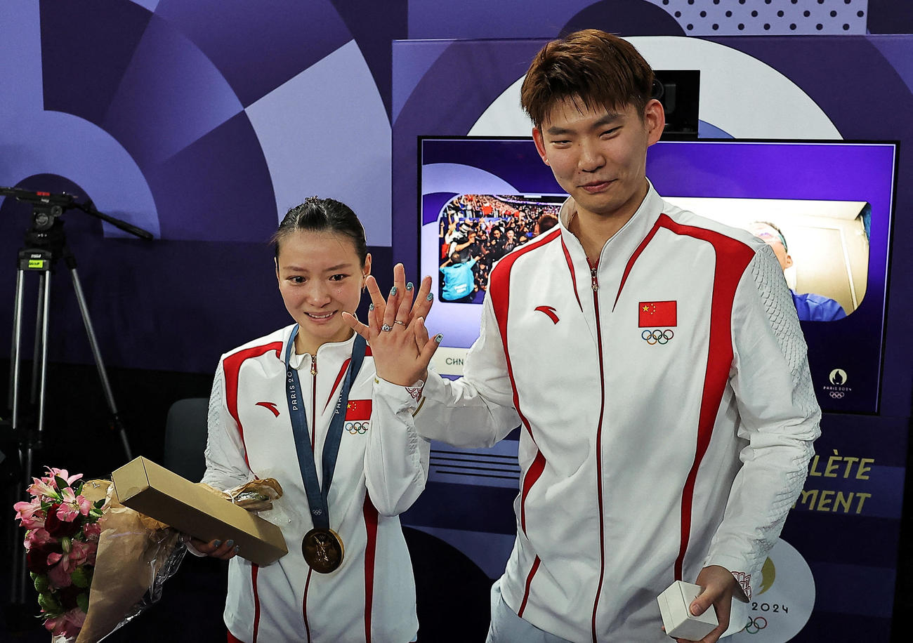 バドミントン混合ダブルスの表彰式後に優勝した中国の黄雅瓊（左）はペアを組む劉雨辰から公開プロポーズを受けた（ロイター）