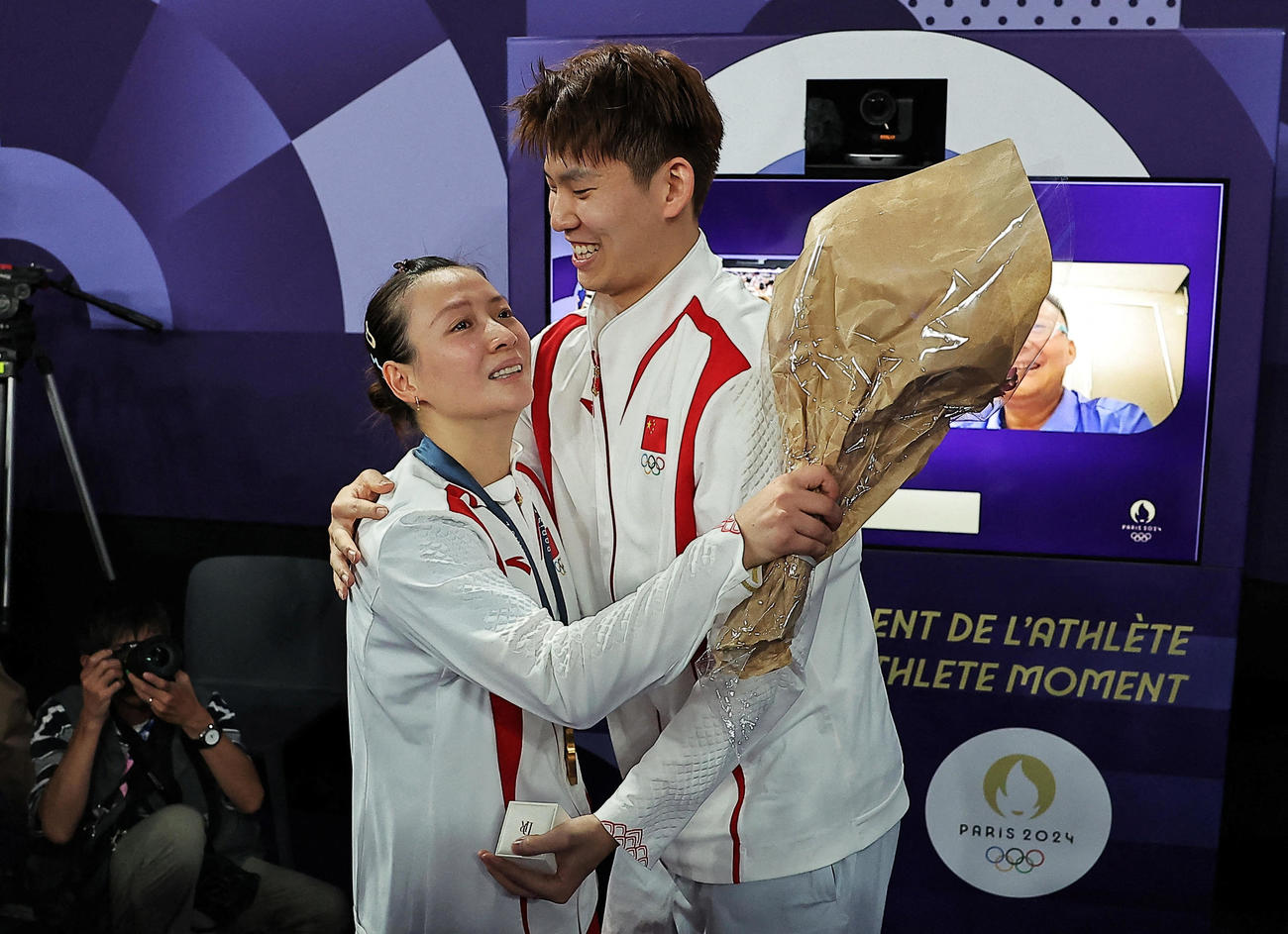 バドミントン混合ダブルスの表彰式後に優勝した中国の黄雅瓊（左）はペアを組む劉雨辰から公開プロポーズを受けた（ロイター）
