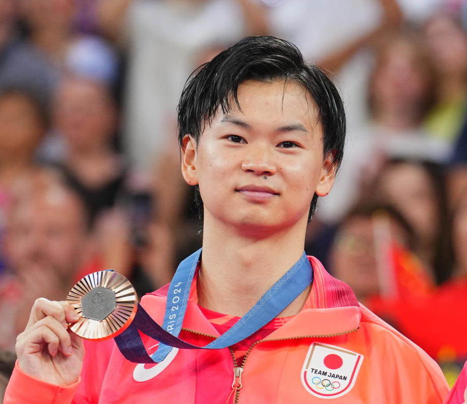 バドミントン混合ダブルス3位決定戦、銅メダルを手に笑顔を見せる渡辺勇大（2024年8月2日撮影）