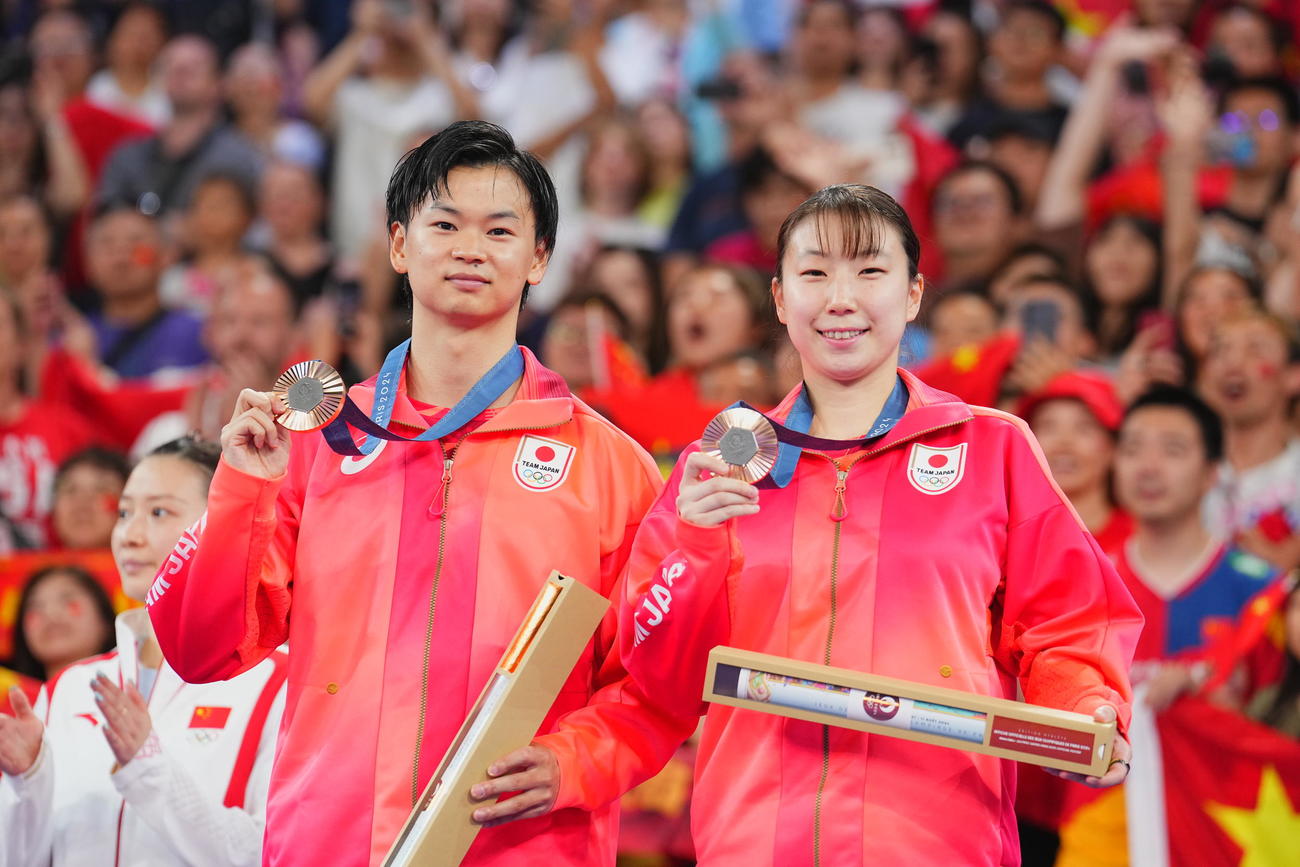 バドミントン混合ダブルス3位決定戦、銅メダルを手に笑顔を見せる渡辺勇大（左）、東野有紗組（2024年8月2日撮影）