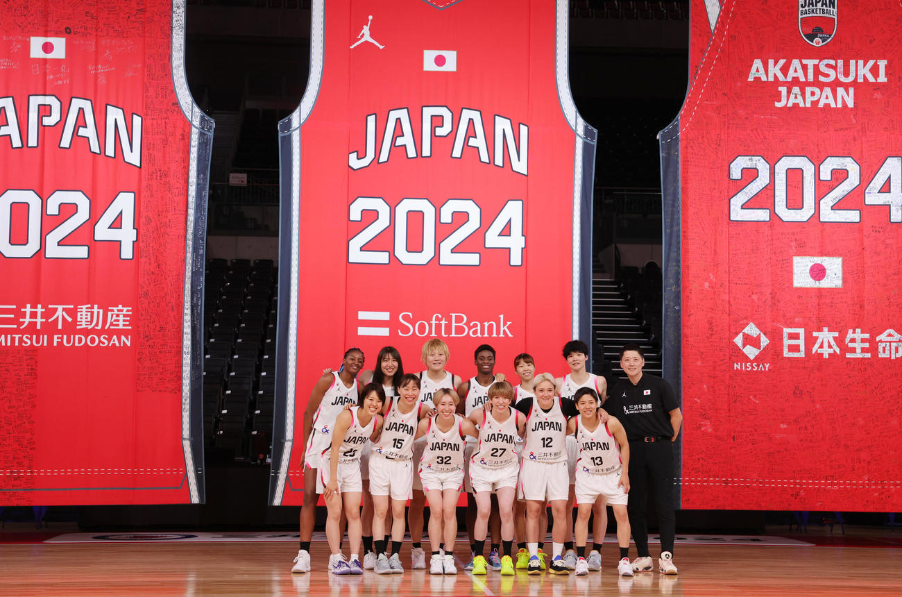「日本一丸」イベントで記念写真に納まバスケットボール女子日本代表の選手と恩塚亨監督（右端）（撮影・野上伸悟）