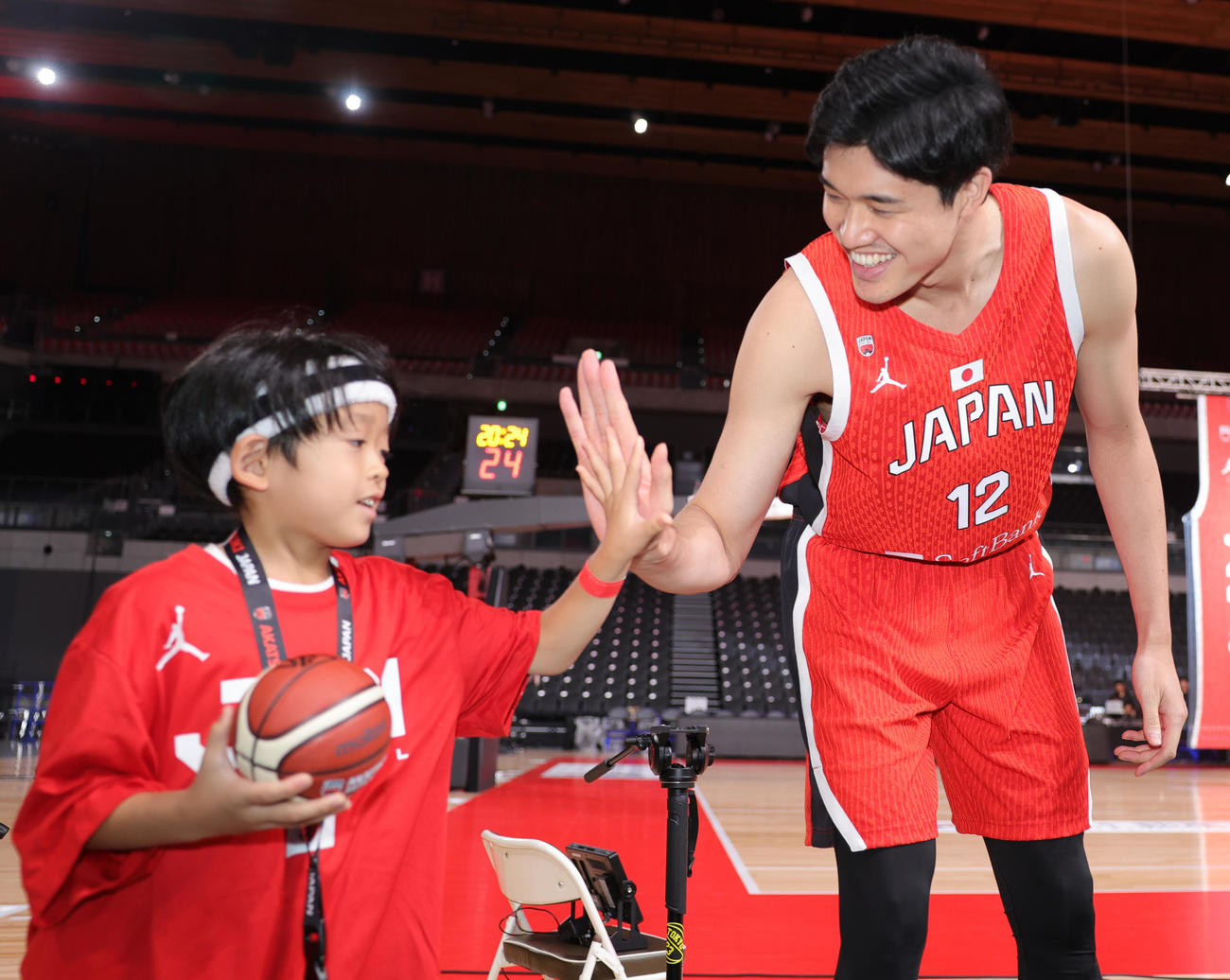 「日本一丸」イベントで、ヘアバンドをした少年ファンにサインをし、ハイタッチするバスケットボール男子日本代表の渡辺雄太（撮影・野上伸悟）