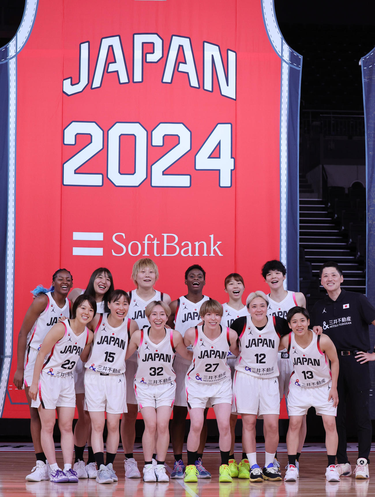 「日本一丸」イベントで記念写真に納まバスケットボール女子日本代表の選手と恩塚亨監督（右端）（撮影・野上伸悟）