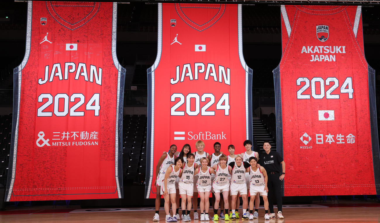 「日本一丸」イベントで記念写真に納まバスケットボール女子日本代表の選手と恩塚亨監督（右端）（撮影・野上伸悟）