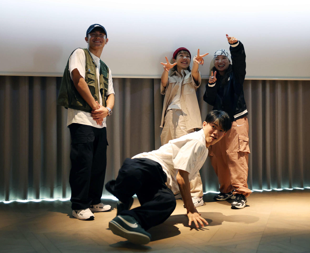 フォトセッション中、即興で踊るパリ五輪ブレイキン日本代表Hiro10（手前）と笑顔の左からShigekix、AYUMI、AMI（撮影・宮地輝）
