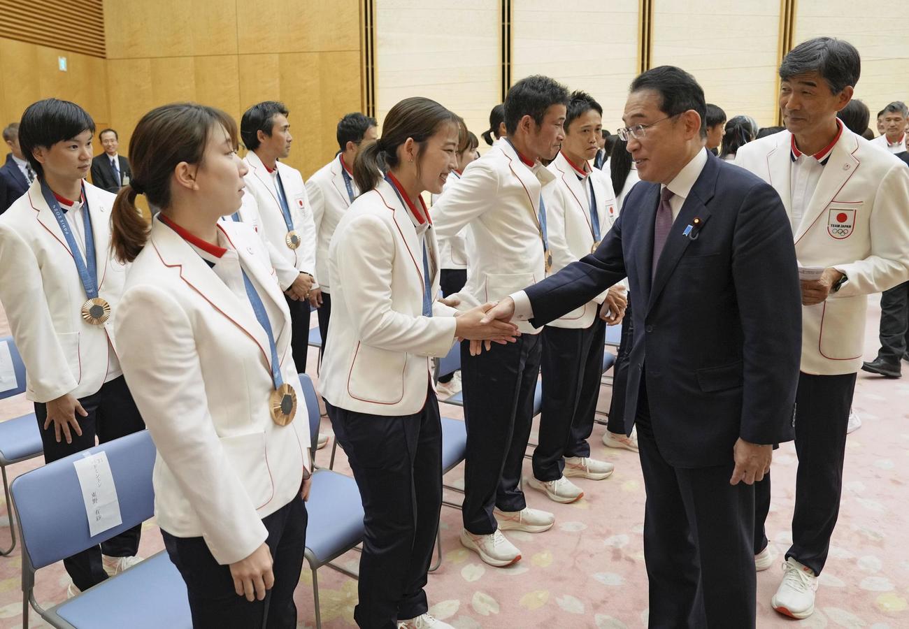 パリ五輪の日本選手団メダリストらと握手を交わす岸田首相（右手前）（共同）
