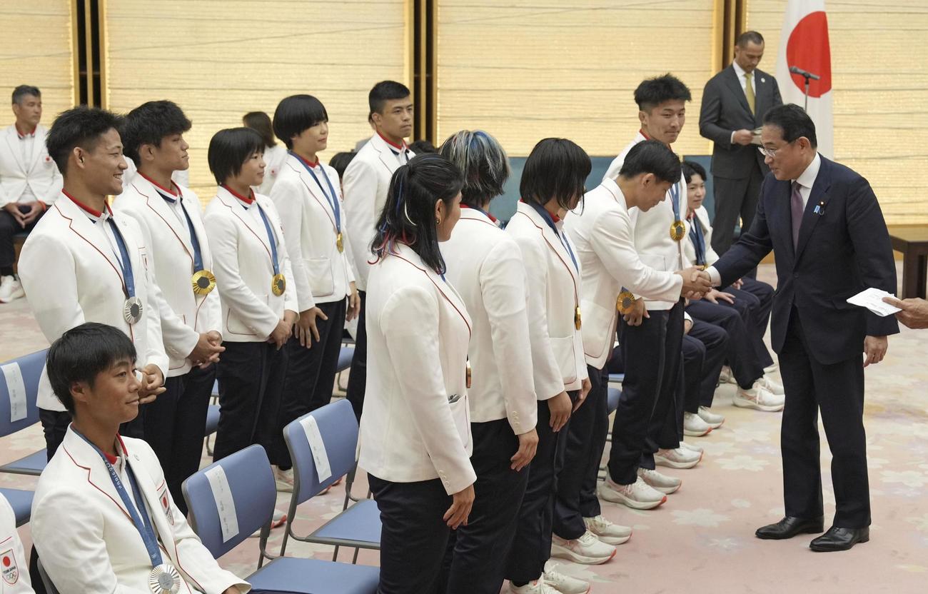 パリ五輪の日本選手団メダリストらと握手を交わす岸田首相（右端）（共同）