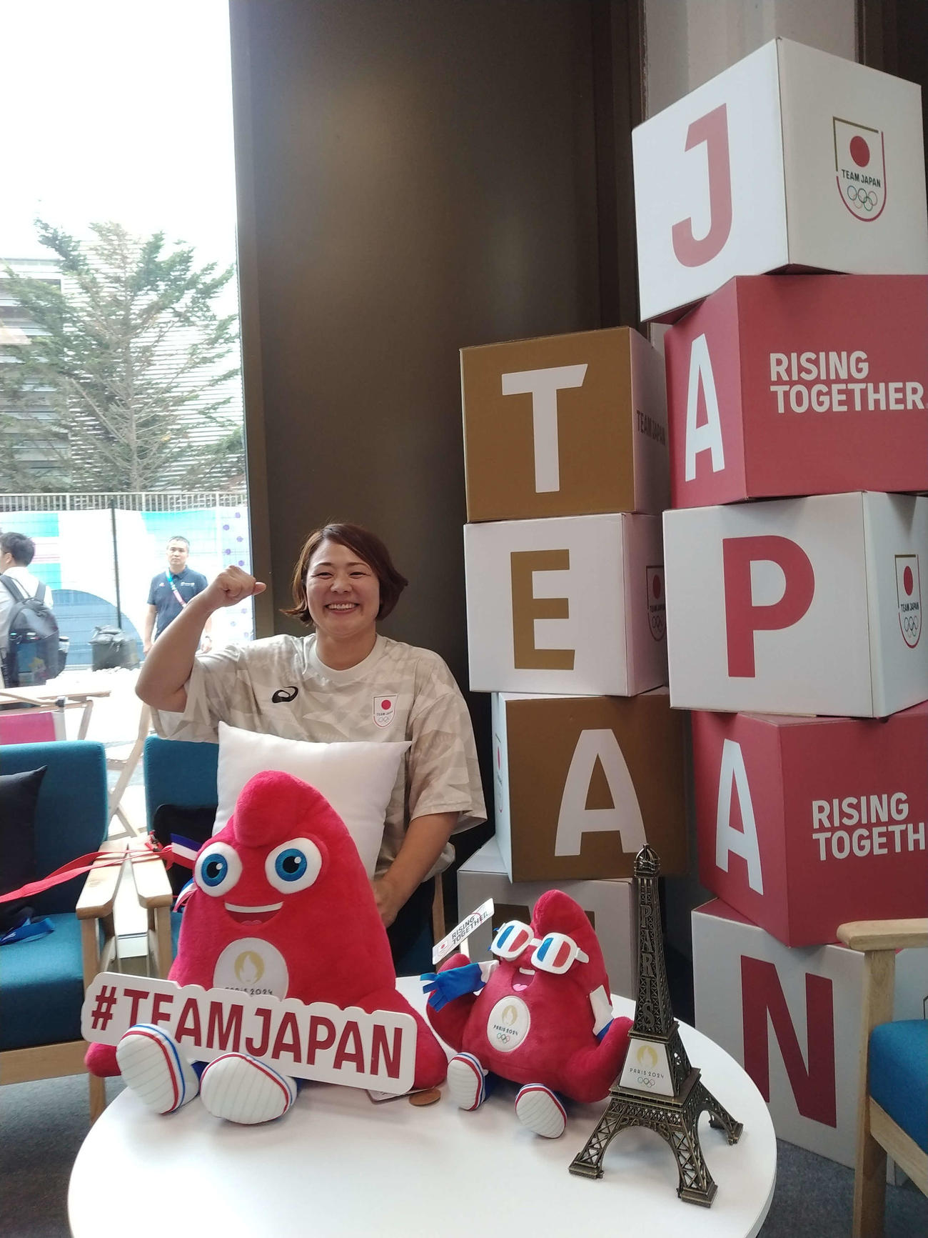 日本の宿泊棟の1階に設置された「TEAM JAPAN Cafe」。選手用に設けられた撮影スポットで笑顔の谷本さん