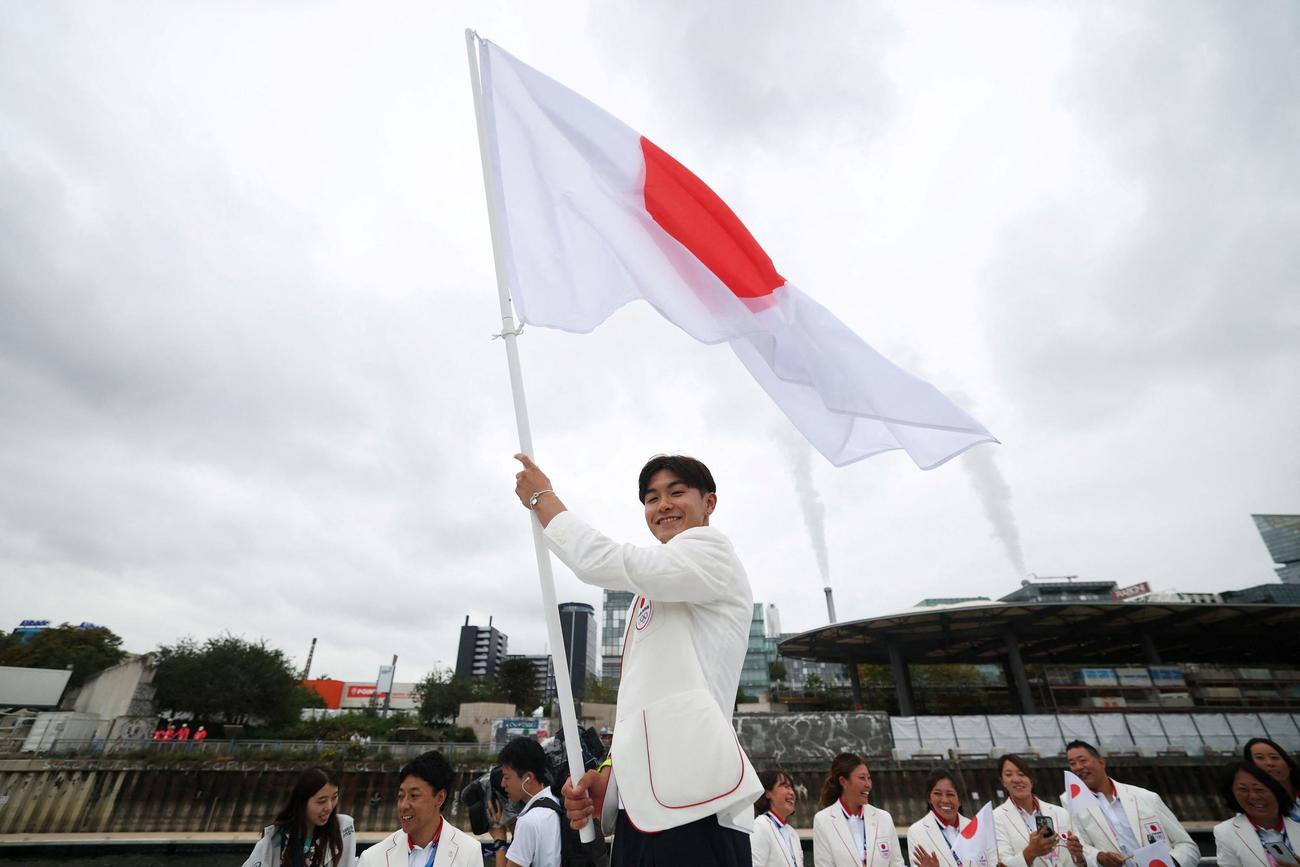 開会式でセーヌ川沿いの選手パレード中に日の丸を振る日本代表の旗手であるシゲキックスこと半井成之（ロイター）