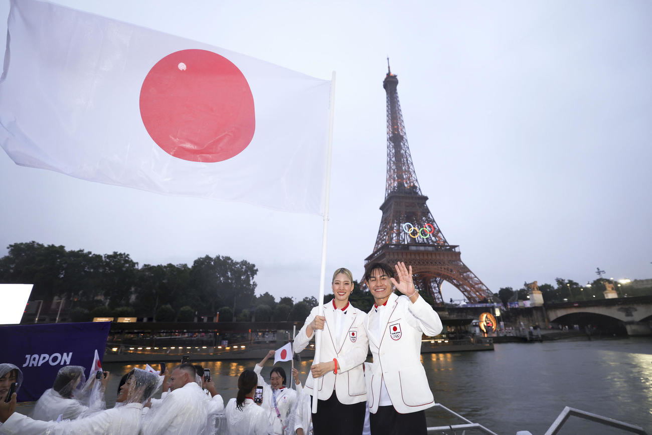 セーヌ川で行われたパリ五輪の開会式パレードで、写真に納まる旗手の江村美咲（左）と半井重幸。後方はエッフェル塔（ゲッティ＝共同）