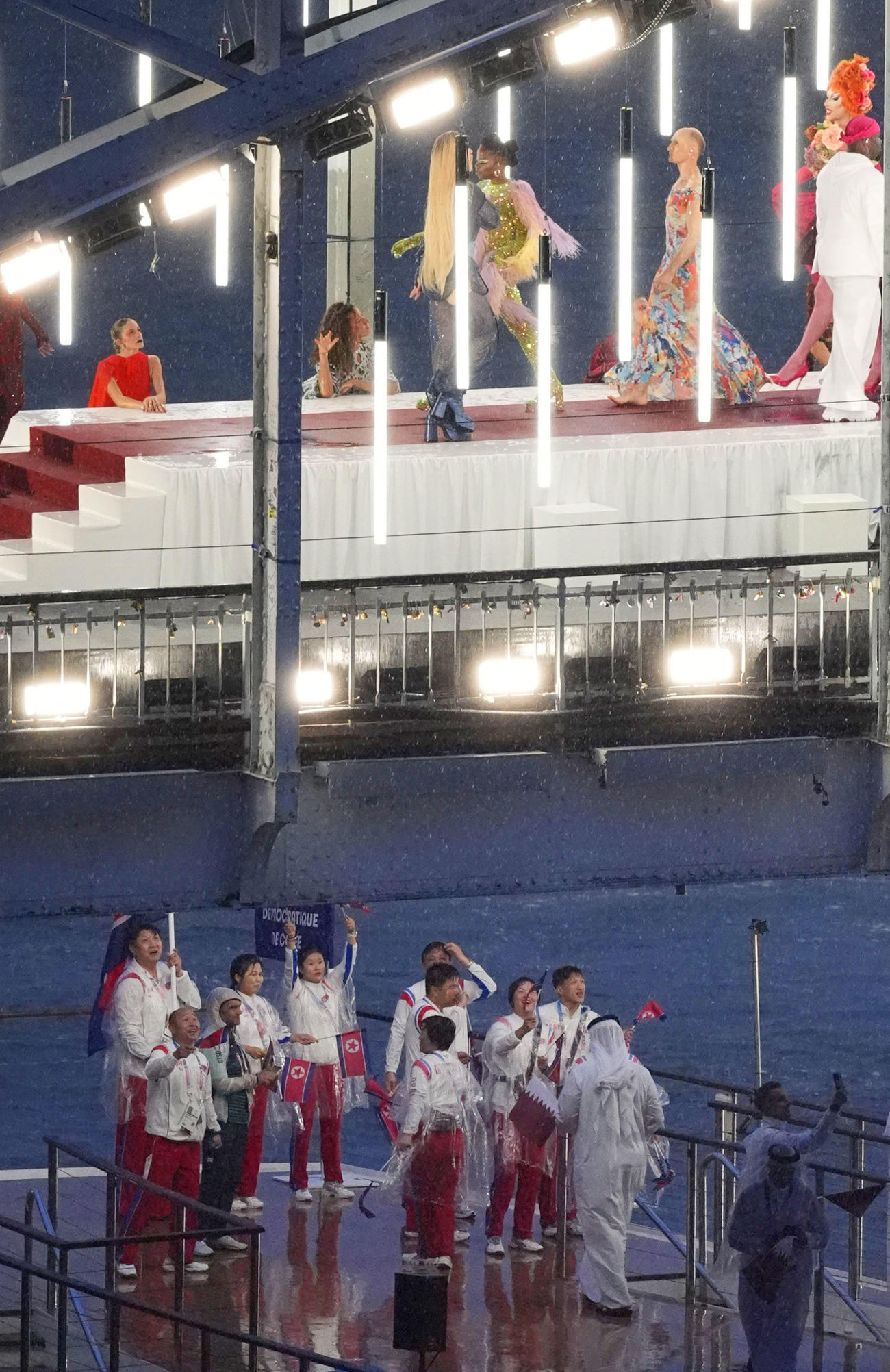 パリ五輪の開会式で、セーヌ川を船でパレードする北朝鮮選手団（下、共同）