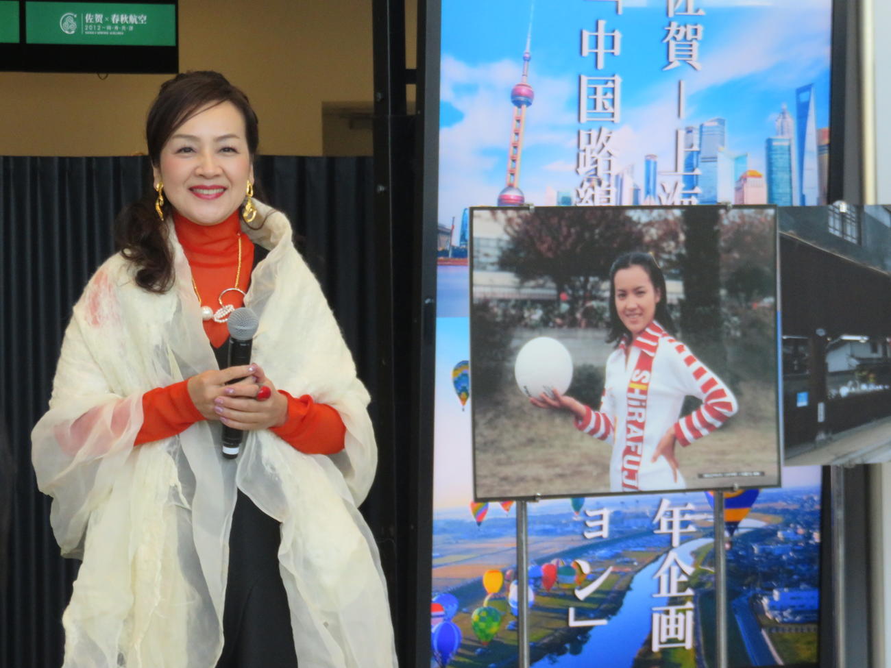 「佐賀－上海就航線10周年企画『中国路線プロモーション』」イベントに出席した荒木由美子と「燃えろアタック」のパネル（2022年1月18日）