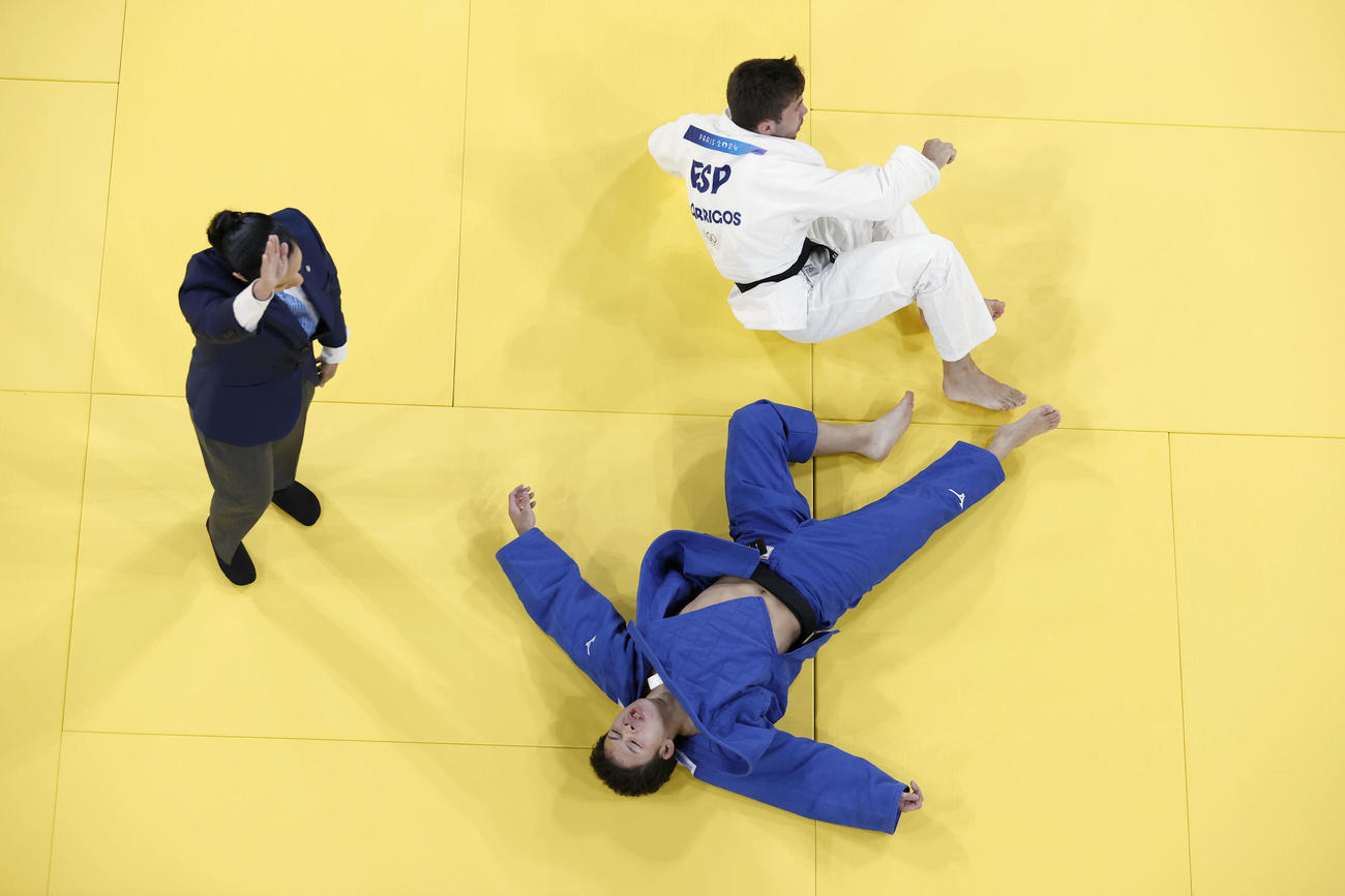 男子60キロ級準々決勝　ガルリゴス（上）の締め技で敗れ、畳の上で大の字になる永山竜樹（共同）
