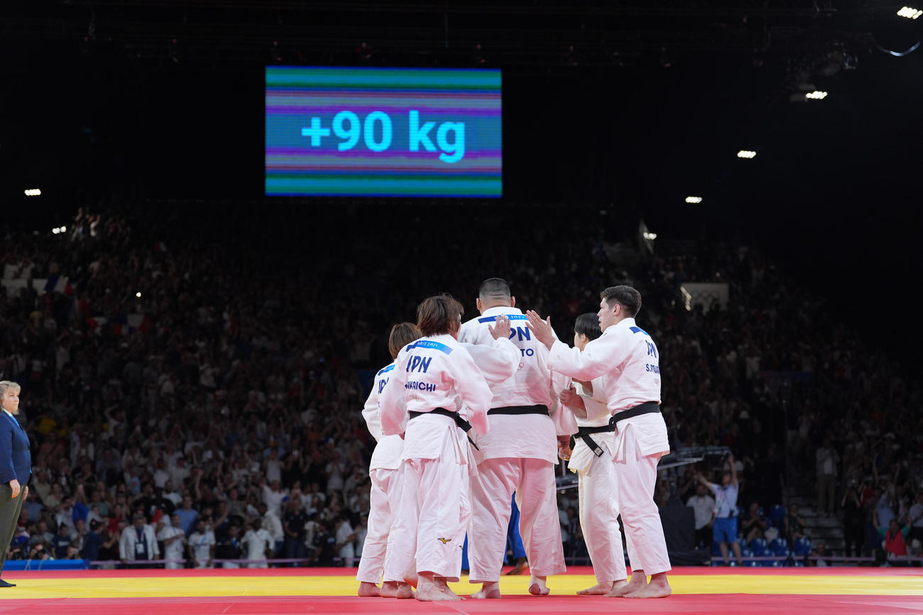 パリ五輪　混合団体決勝　フランスとの対戦で3－3となり、代表戦はルーレットによる抽選で男子90キロ超級と決定。決戦に臨む斉藤立を激励する日本チームの面々（撮影・パオロ　ヌッチ）