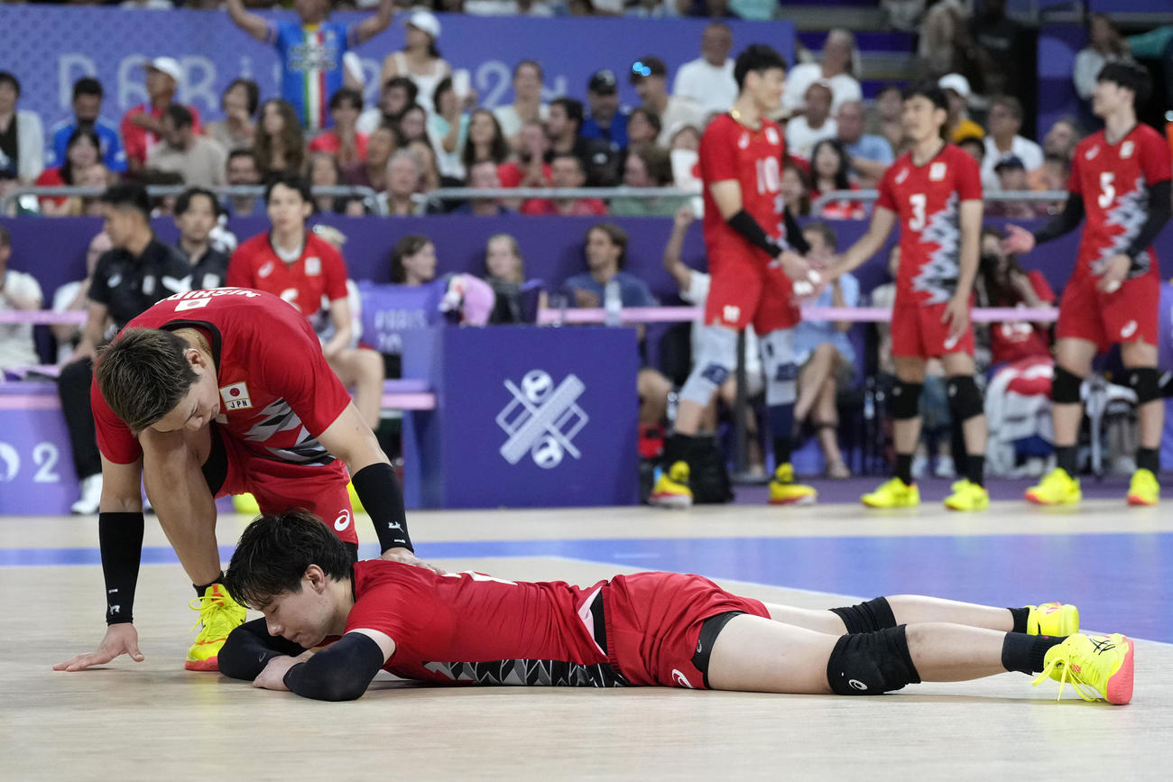 準々決勝敗退となり、コートに倒れ込む高橋藍に声をかける西田有志（AP)