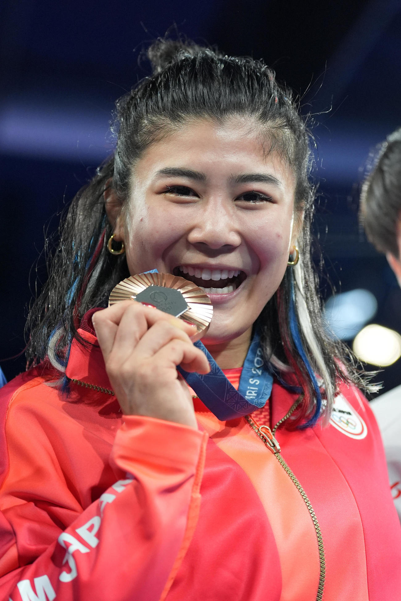 パリ五輪　女子フリースタイル68キロ級　表彰式で銅メダルをかみ、笑顔を見せる尾崎野乃香（撮影・パオロ　ヌッチ）