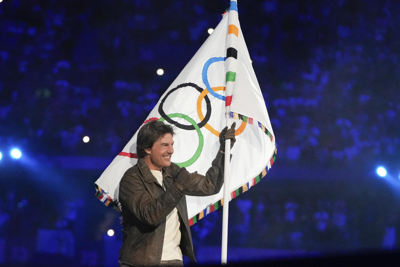 パリ五輪閉会式　五輪旗を手に笑顔のトム・クルーズ（AP)