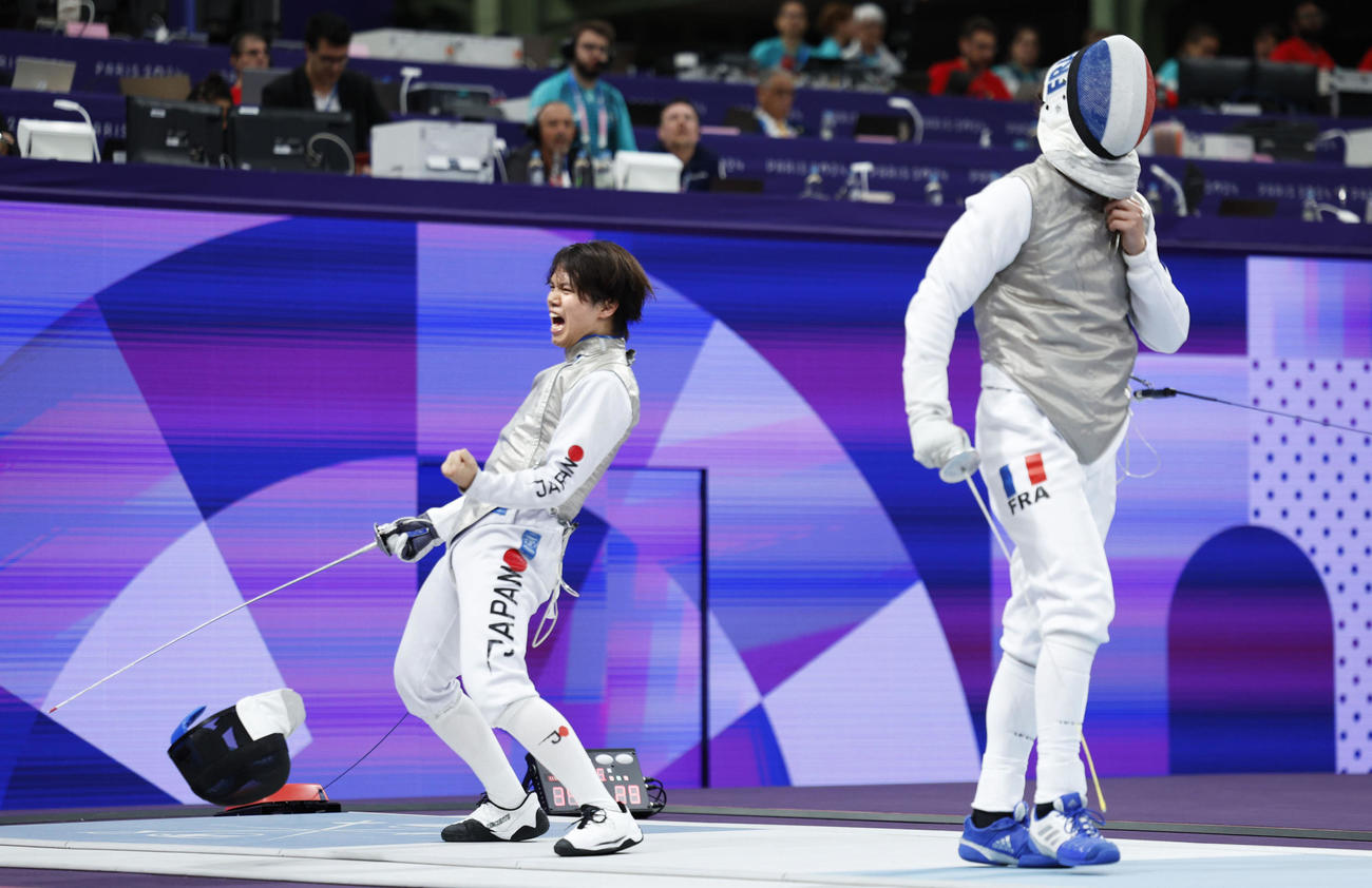 男子フルーレ団体準決勝　フランス選手（右）からポイントを奪い、ガッツポーズする飯村（共同）