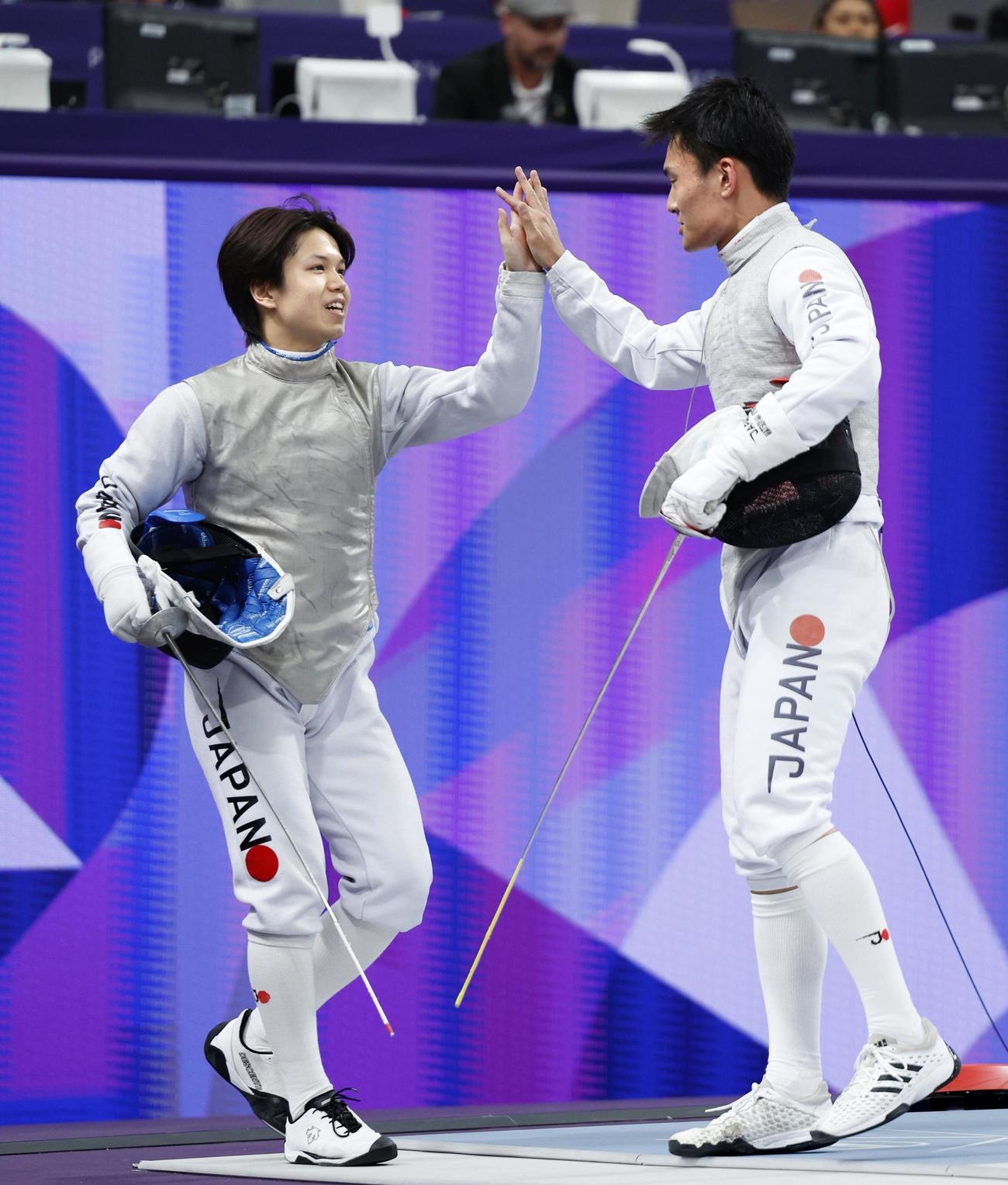 男子フルーレ団体準決勝　松山（右）とタッチで交代する飯村（共同）
