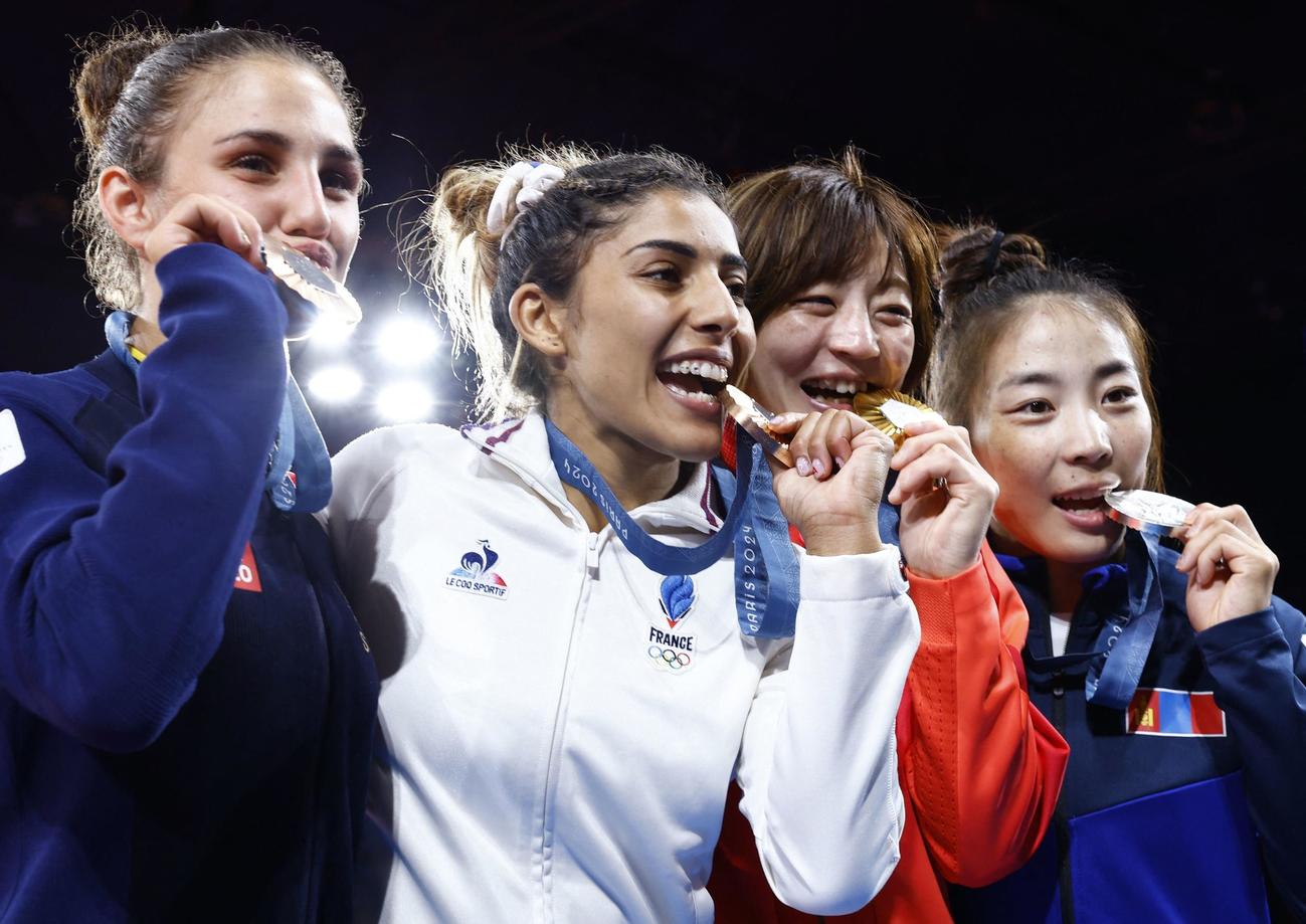 メダルセレモニーでメダルを噛むポーズをする角田夏実（右から2人目）（ロイター）