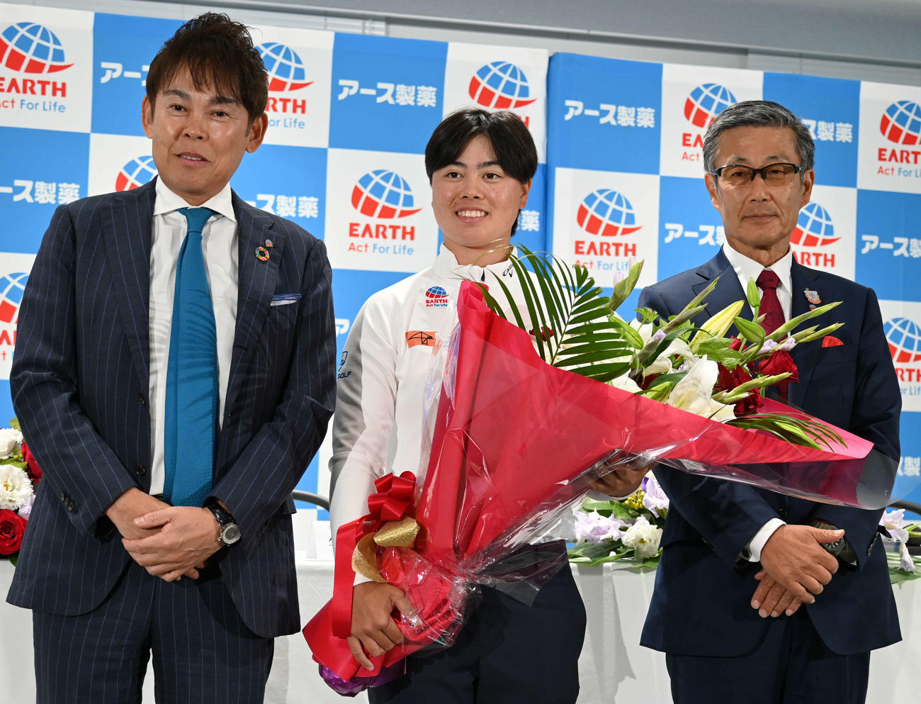アース製薬大塚会長（右）、川端社長（左）から花束を贈られ笑顔を見せる笹生（撮影・飯岡大暉）