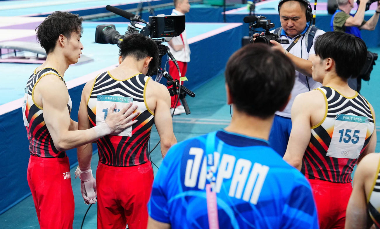 体操男子団体決勝、最終種目の鉄棒の演技を前に仲間たちに背中をたたくよう促す橋本（左から2人目）（撮影・垰建太）