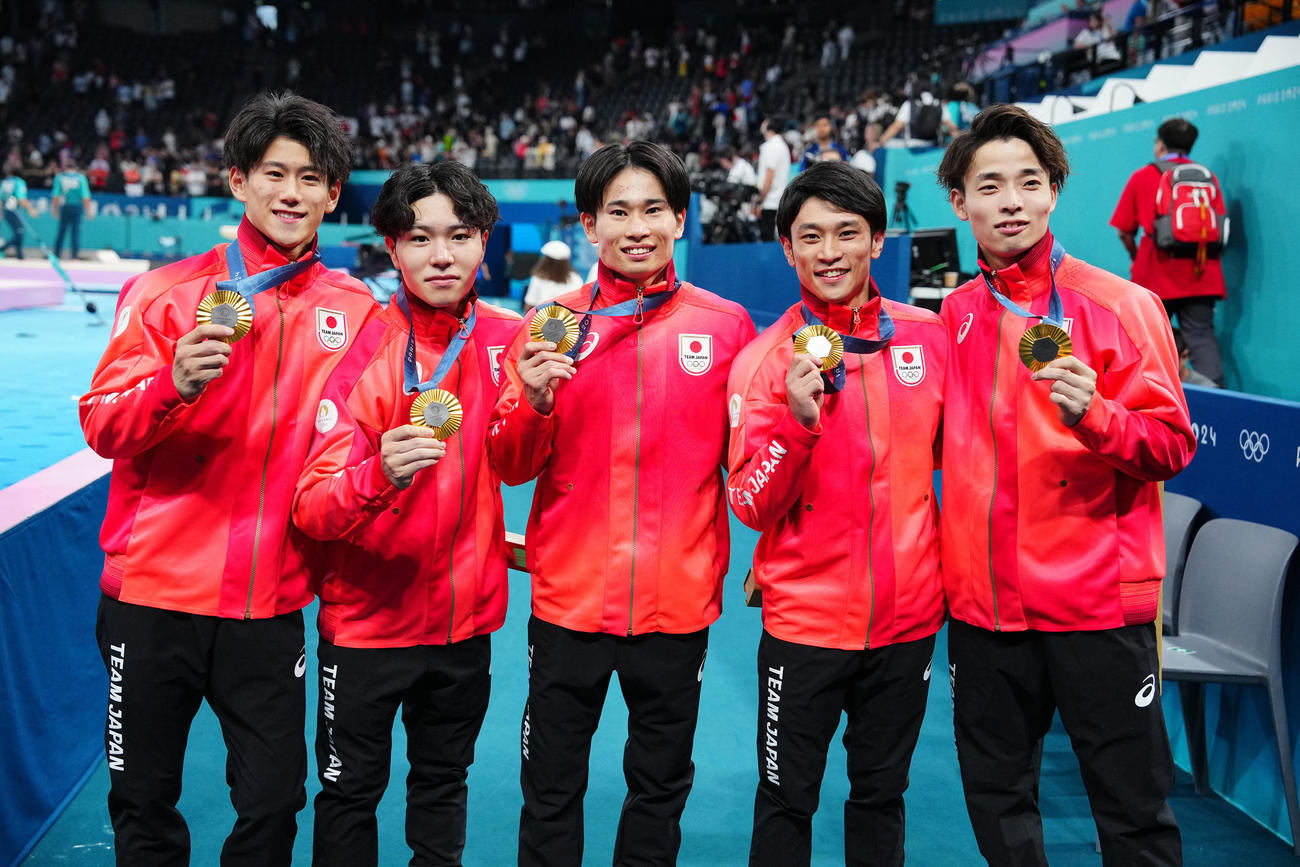体操男子団体決勝、金メダルを手に写真に納まる日本の選手たち。左から橋本、岡、萱、谷川、杉野（撮影・垰建太）