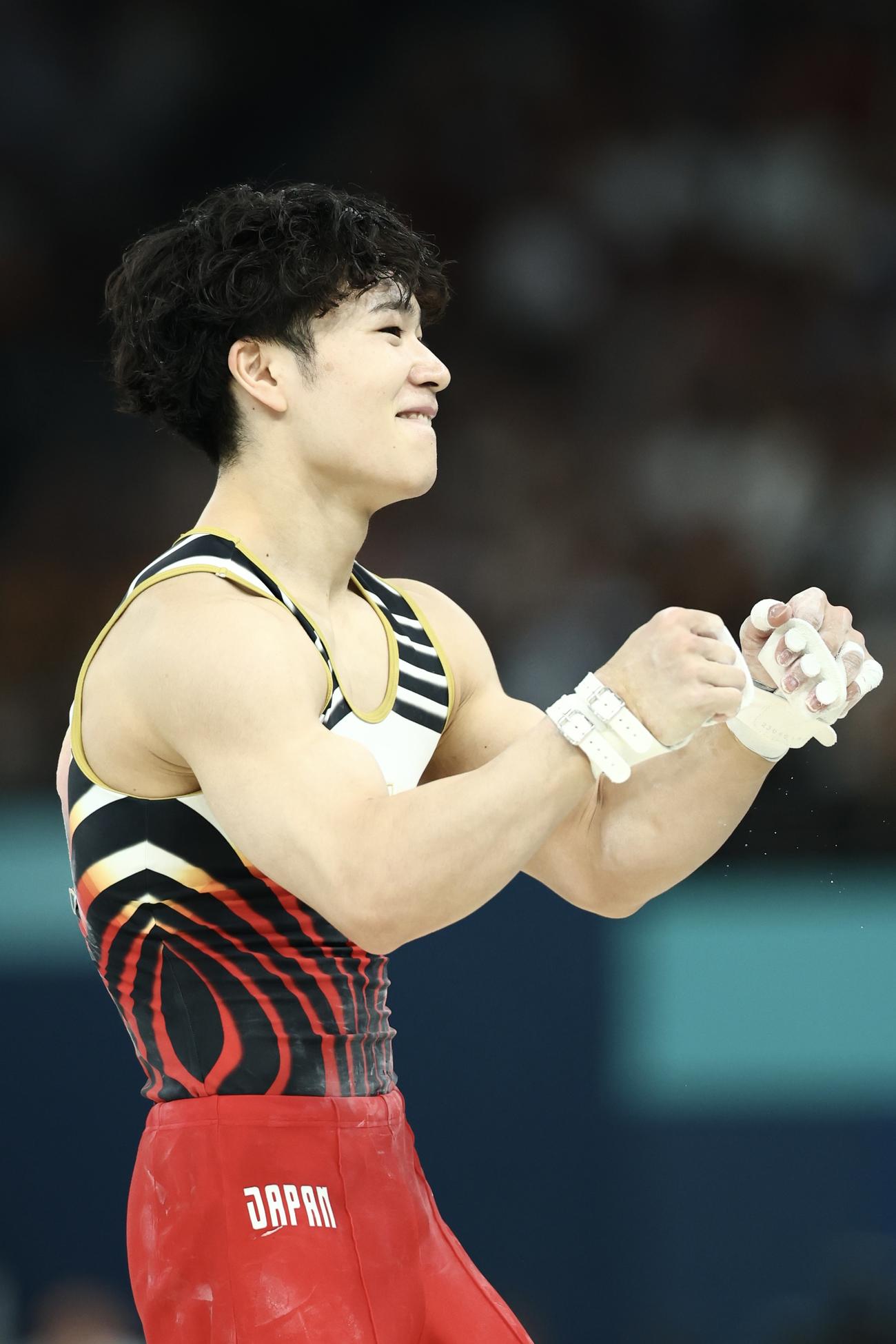 男子個人総合決勝　鉄棒の演技で着地を決め、笑顔でガッツポーズする岡（撮影・河田真司）