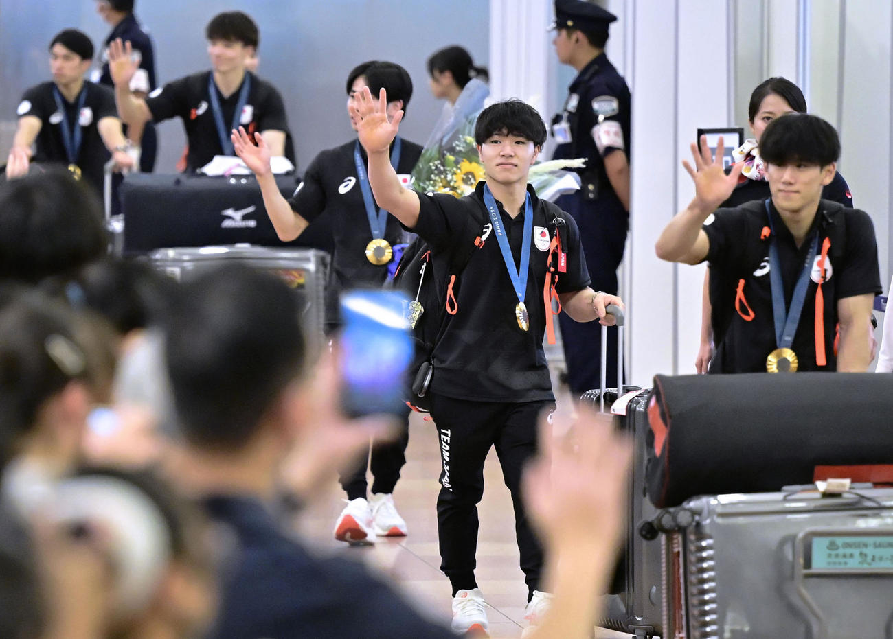 パリ五輪を終え帰国した体操男子で3冠の岡慎之助（右から2人）ら代表選手＝8日、羽田空港（共同）