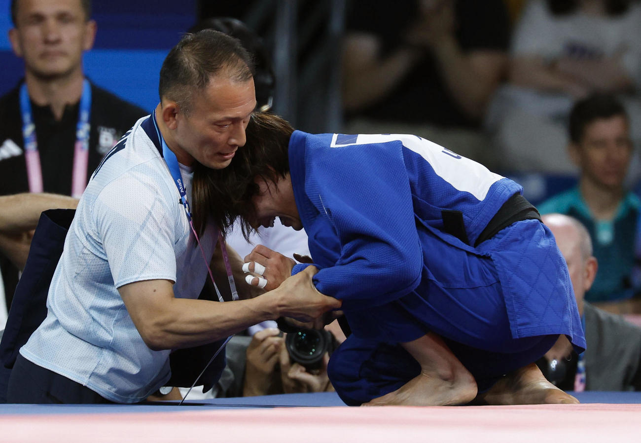 女子52キロ級2回戦で敗れ号泣する阿部詩。左は平野幸秀コーチ（共同）