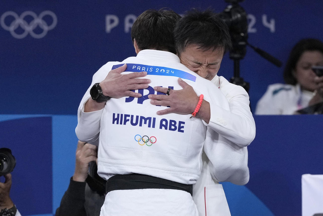男子66キロ級決勝　五輪連覇を達成しコーチと抱き合う阿部一二三（AP)
